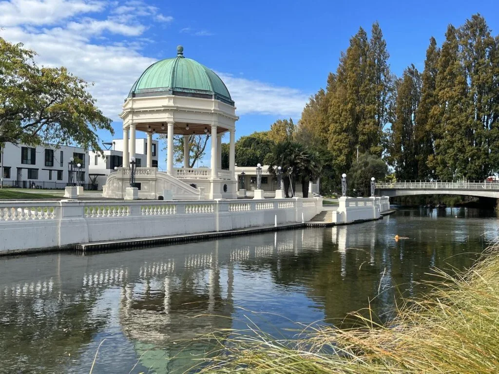 The Edmonds Band Rotunda in Christchurch, cream painted columns and balustrade beside the Avon