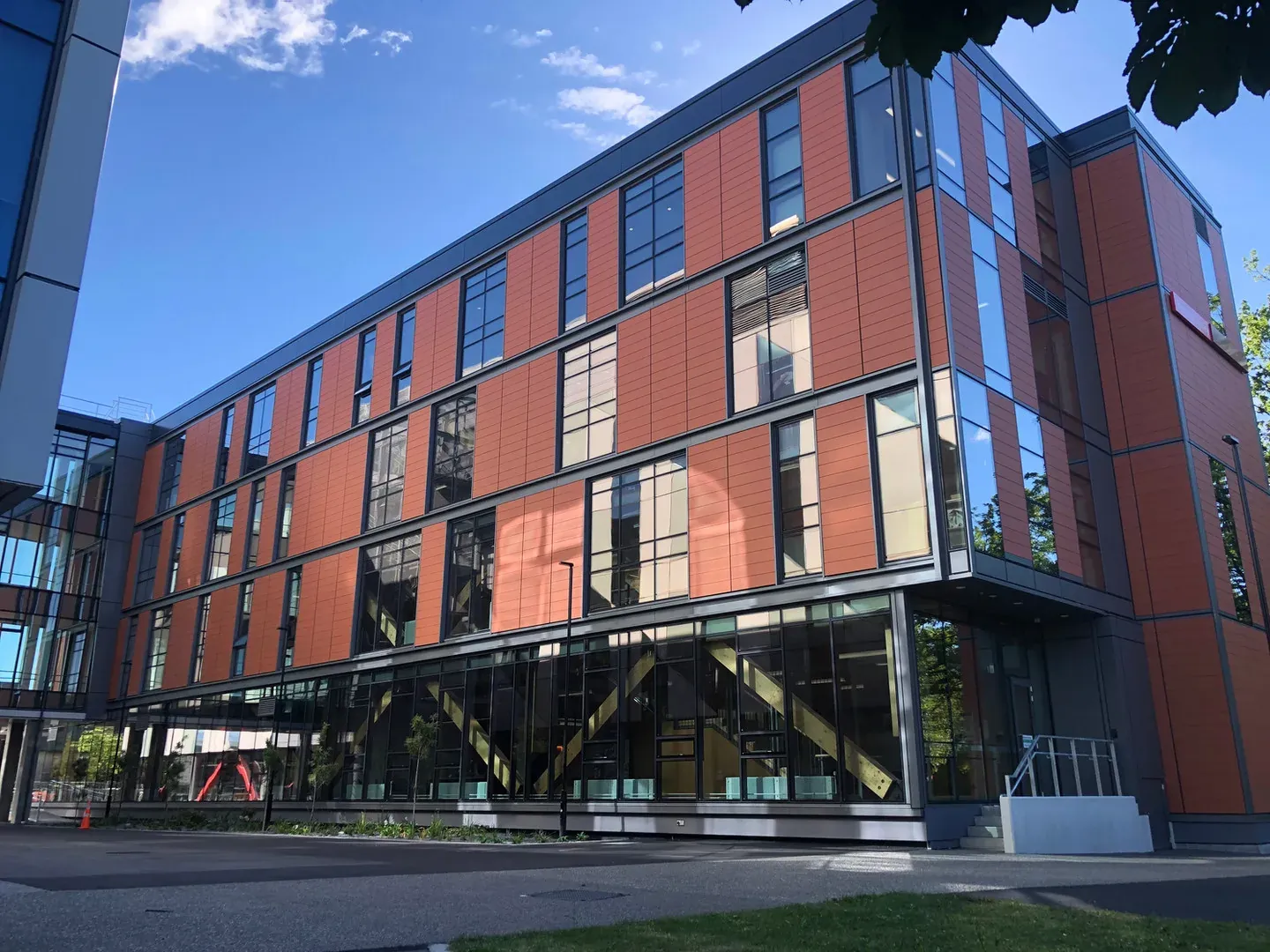 The Beatrice Tinsley Building at the University of Canterbury, terracotta panels and dark glazing rising four storeys against a clear sky