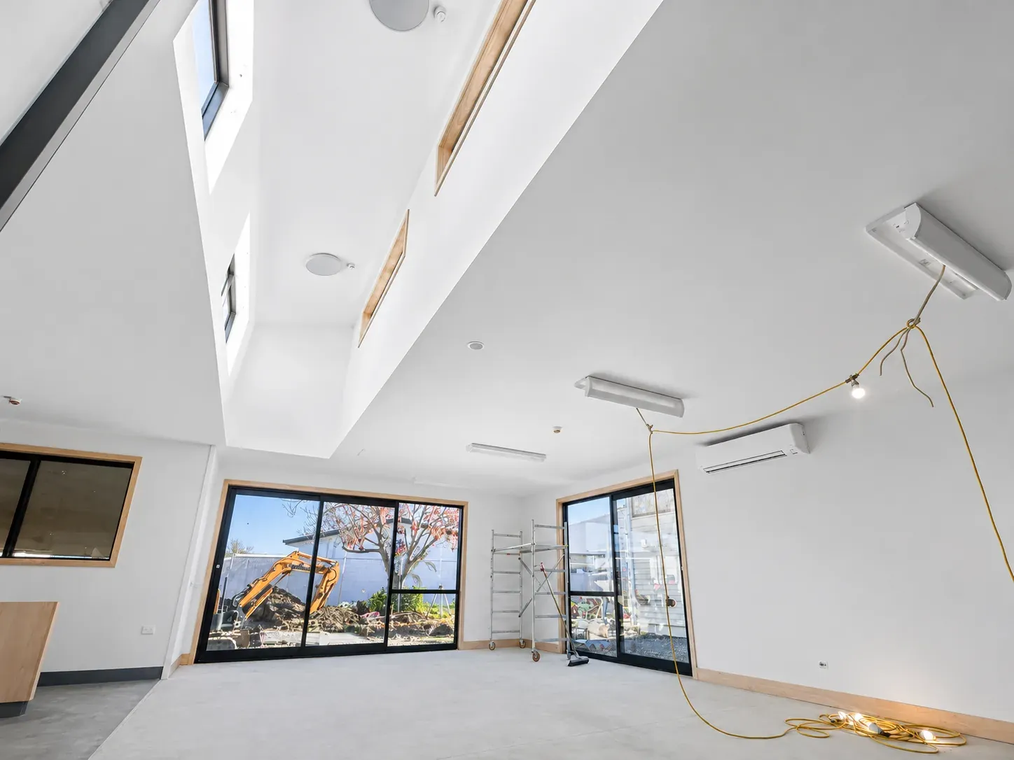 A newly finished classroom at St Mary's School, white walls and ceiling under angled skylights, the site still in progress beyond the windows