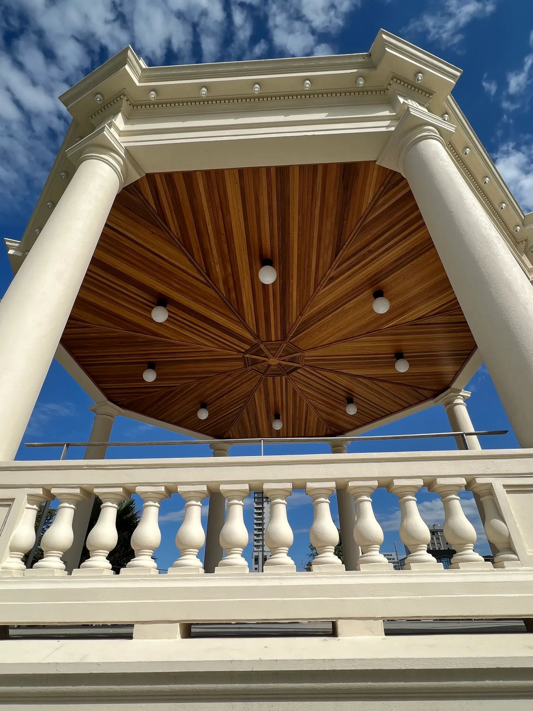 Looking up into the rotunda, the red cedar ceiling radiating in a starburst from a central boss, framed by cream columns and balustrade
