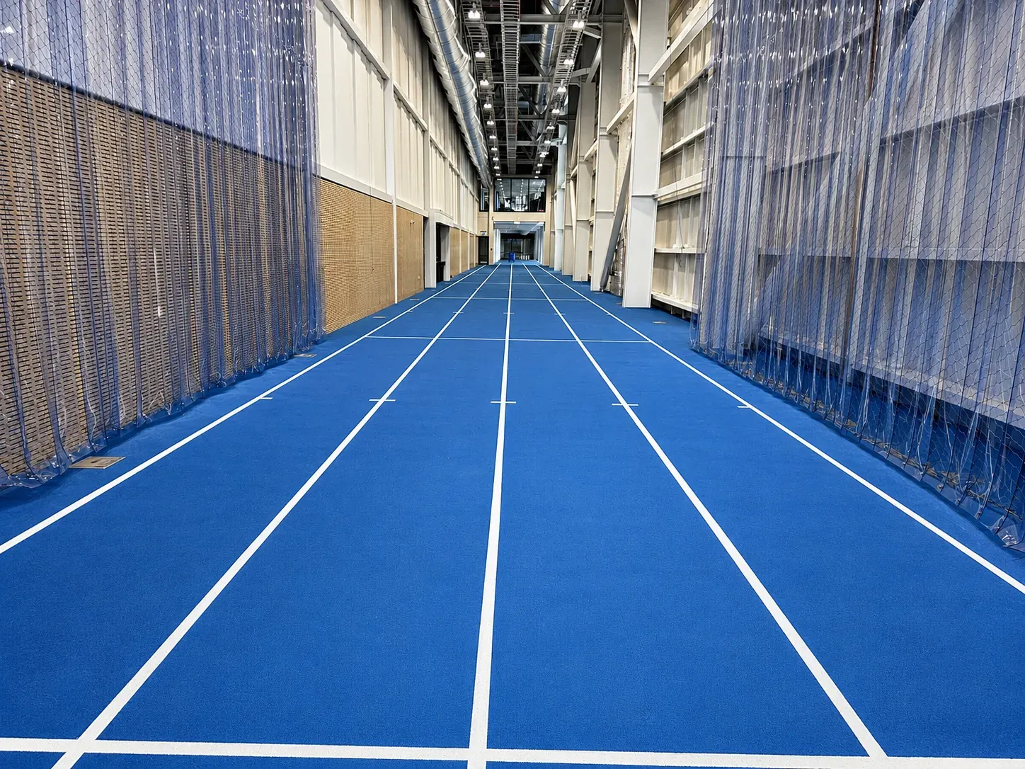A further view along the Parakiore sprint track, lane lines running between retractable netting