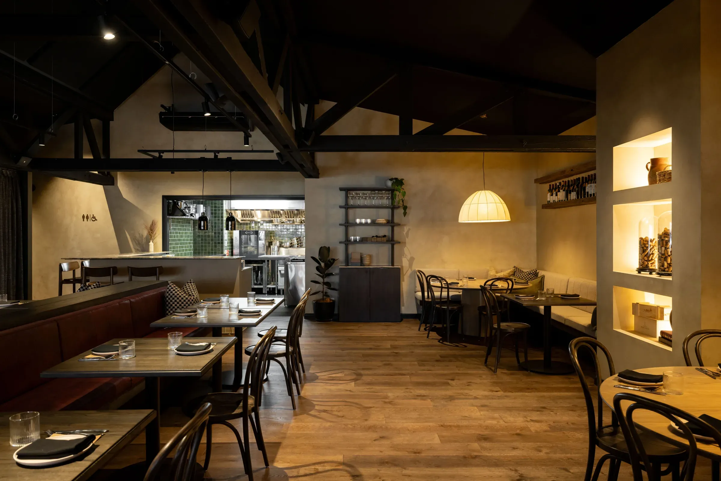 The main dining room at Toast and Oak, warm French Wash walls under exposed dark roof trusses